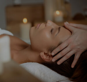 Young beautiful girl having face massage relaxing in spa salon.